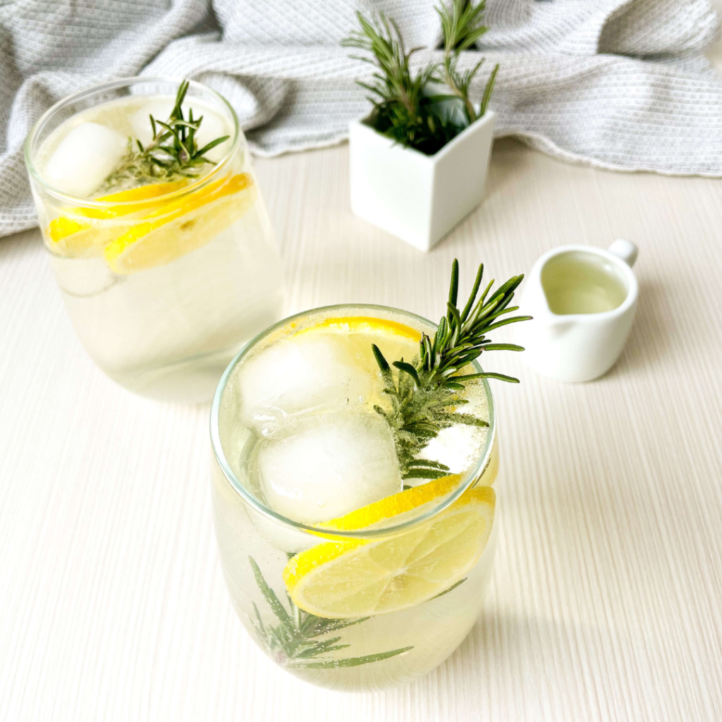 Apple Rosemary Gin Fizz: Two glasses with a small pitcher of lemon juice beside